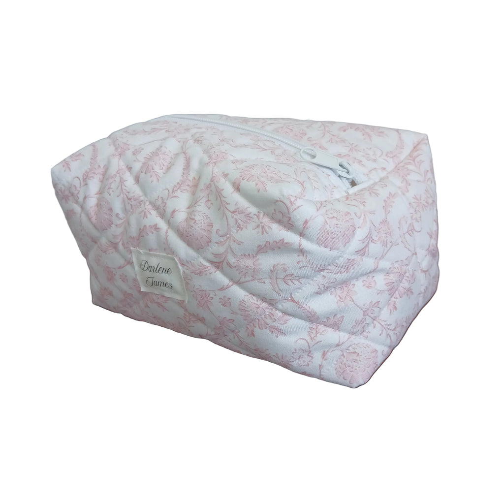 Pink floral-patterned pouch with a brand label attached