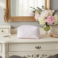 Pink floral quilt with a label on a white desk