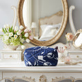 Folded blue fabric with white floral pattern and a visible brand label on a wooden surface.