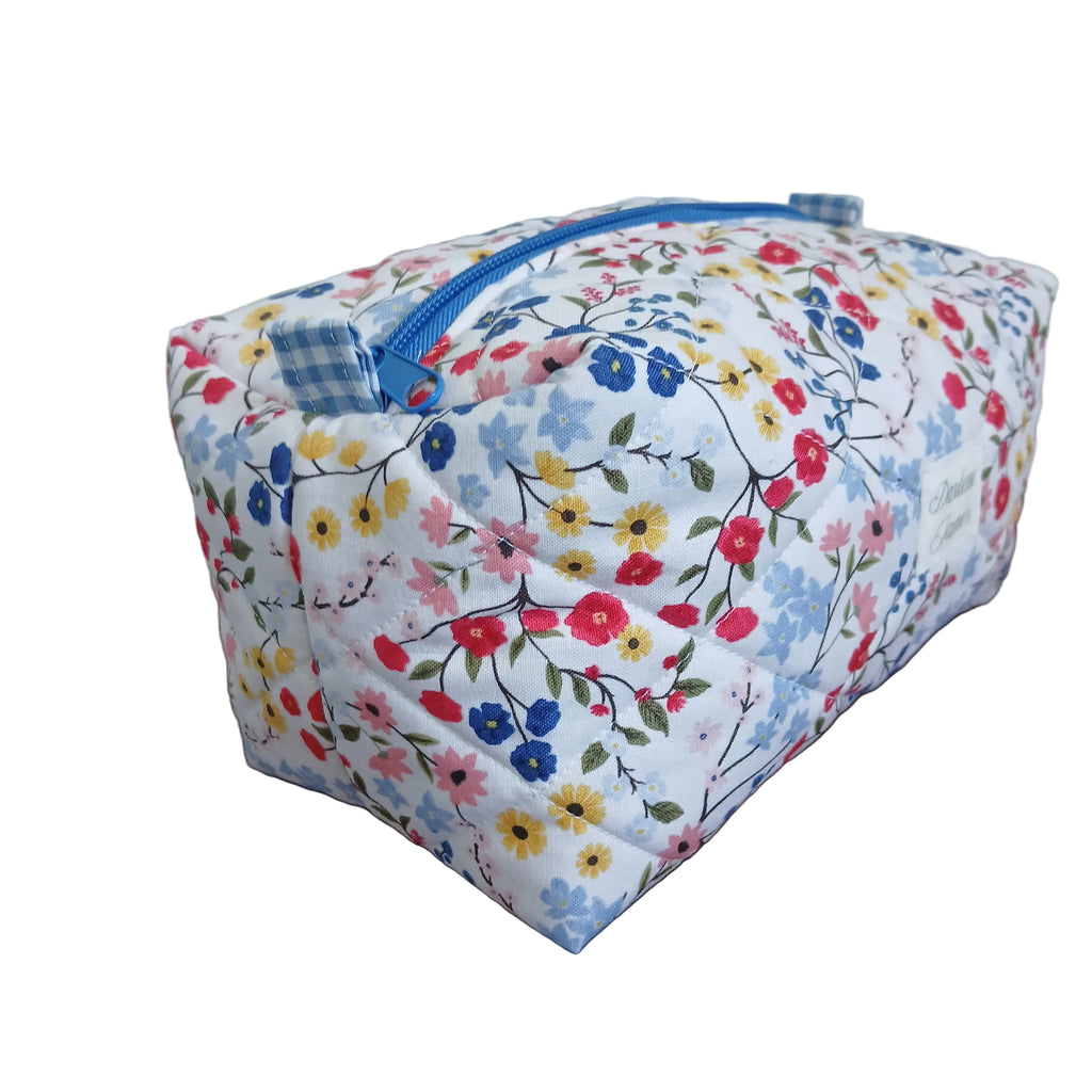 Floral-patterned pouch with a blue zipper on a wooden surface