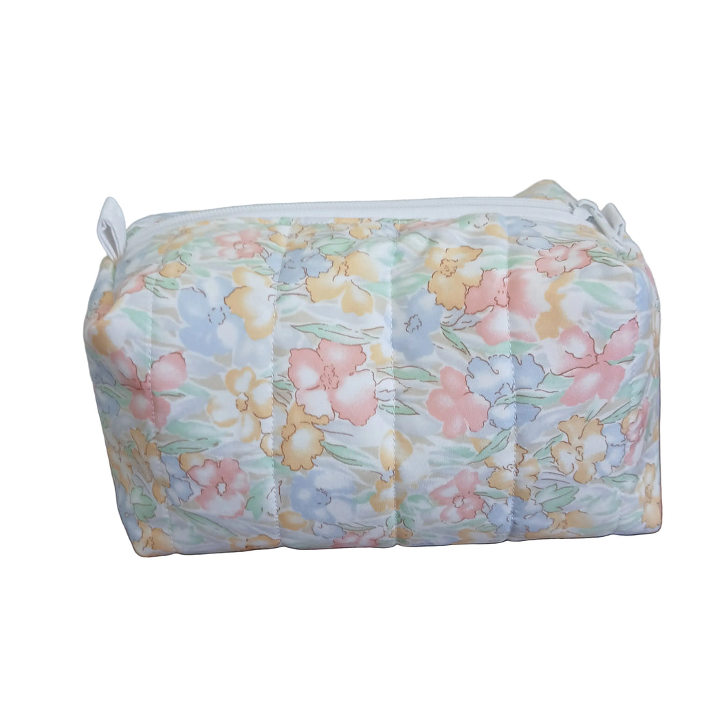 Floral-patterned pouch on a wooden surface with a neutral background